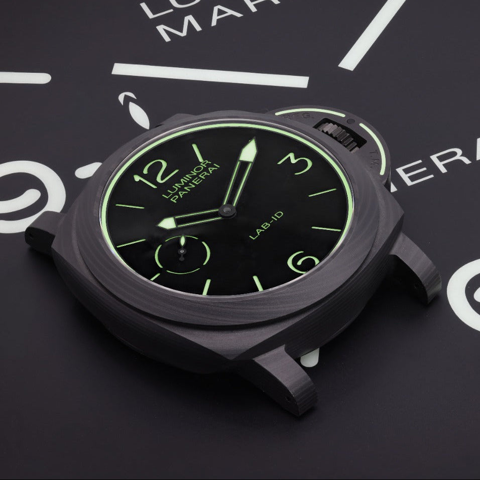 A Luminor Marina watch by Panerai, featuring a matte black case and a black dial with glowing green indices, displayed on a dark background with white clock markings.
